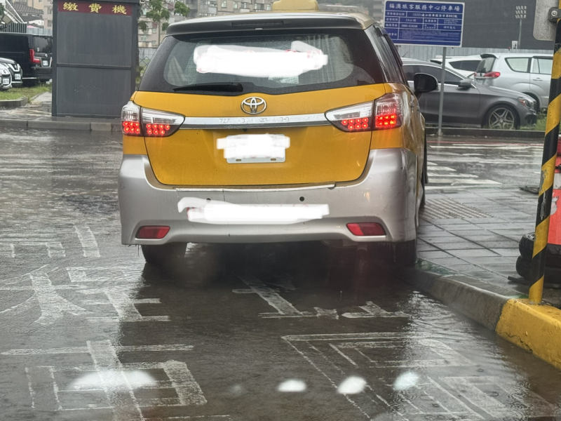 路面積水導致計程車要跨上人行道，避免乘客踩水，積水範圍不小