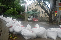 　山隴郵局路口設置沙包防線，避免排水溝容不了過多的雨水，造成介壽商場淹水。（圖／文：邱竟瑋）
