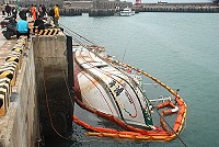 「鴻海號」拖至漁船碼頭固定後,潛水人員下水展開封艙救船的工作。(圖/文:陳其敏)