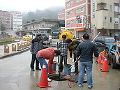 環保局配合下水道啟用,忙著清理各村堵住了管路的濁白油塊。(圖:本報編輯部)
