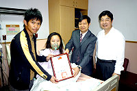 縣長楊綏生頒發感謝狀給以CPR技能搶救遊客的周治孝,表揚他的熱心助人義舉,躺在病床上的是周治孝太太施怡夢。周治孝助人又愛妻,被認為是馬祖的新好男人。(圖:連江縣消防局提供)