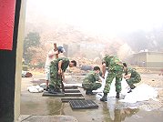 馬祖復興油庫十六日上午山崩,落石砸破了油堡前方的油桶,軍方與台電人員聯手設置吸油棉,阻止破桶汙泥擴散,縣府環保局也出動人力、設備,協調海巡監控。(圖/文:邱竟瑋)