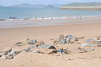 　塘后沙灘夏日戲水人潮多，工程遺留大量碎石，公