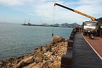 　南竿鄉海堤災損復建工程刻正進行，工程人員將塊石吊放在福清外環道下方的護岸，以減緩波浪。（圖／文：邱竟瑋）