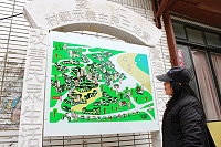 鐵板石製觀光地圖看板架在入村處右側原布告欄窗位置。(圖:曹以鋒)