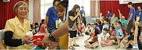 教育局家庭教育中心與仁愛國小合辦祖孫夏令營,小朋友獻上糕點給老奶奶享用。(圖/文:邱竟瑋)