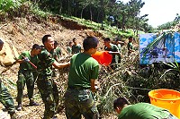弟兄們認真地清理游泳池周圍雜草,杜絕蚊蟲孳生。(圖/文:王仁杰)