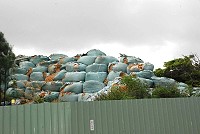 仁愛村電池山清出的汙染廢土數量龐大,軍方陸續運往台灣,廠商展開破包重新包裝。(圖/文:邱竟瑋)