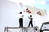 弟兄們不畏寒風,在鷹架上粉刷體育館外的圍牆。(圖/文:康贊清)