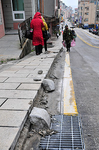 介壽村中隴上坡路段正進行「路緣板」鋪設工程,但遭民眾質疑是否會讓車子更容易停上去;縣府工務局表示,施工前已與居民討論並達成共識,同意採用路緣板施作。(圖/文:曹重偉)