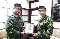 指揮官賀將軍頒贈東引指揮部紀念郵票予即將離職幹部彈補官潘上尉,並合影留念。(圖/文:楊日嘉)