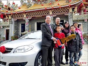 烈嶼鄉長洪成發（左一）將金鑰匙頒給獲得轎車的洪小弟弟（著紅衣者）。（記者吳正庭攝）