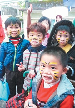 宜蘭縣新兵訓練中心的五結鄉利澤廣惠宮「求虎皮保平安」活動,小朋友彩繪虎臉。(記者廖雅欣/攝影)