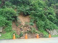 　南竿地區因20日大雨造成多處坍方，縣府工務局21日會同建設局與開口契約廠商執行清除，圖為南竿機場塔台旁日前落石處，已設置警告標誌。（圖：縣府工務局提供）