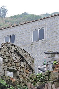 　芹壁閩東建築外觀出現突兀的鋁門窗，住戶若不加裝木門窗將無法通過驗收。（圖／文：陳鵬雄）