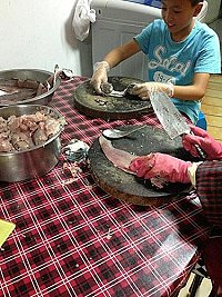 北竿家戶一家大小協力剁魚肉製作魚丸,採用食材馬加魚較經濟實惠。(圖:陳俐琴提供)