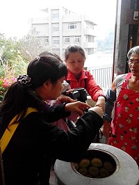 牛角「水官師」曹水官(圖右)自製炭爐烤製繼光餅,採預約制,遊客造訪猛拍鏡頭。(圖:牛角鼎鑫餅舖提供)