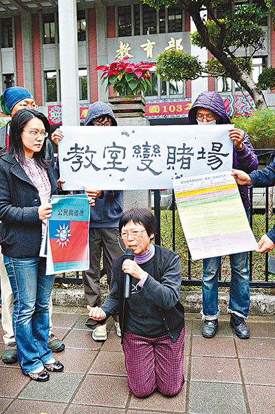 休教師吳麗慧(前中)當場下跪抗議。 中央社