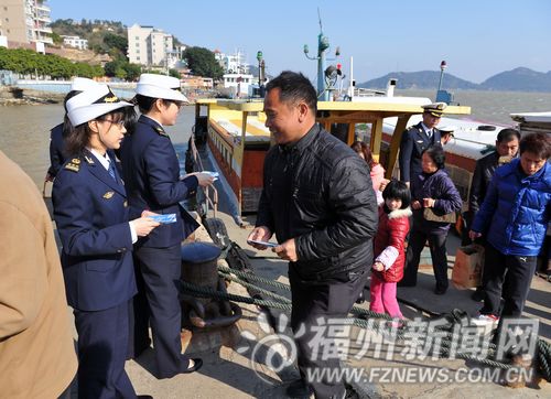 海事志願者在連江琯頭碼頭給上岸的乘客發放交通安全宣傳冊。