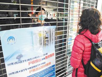 全國戶役政機關電腦29日停擺,北市大安戶政事務所整天拉下鐵門、設告示牌,派員在鐵門內向洽公民眾解釋,被形容好像「探監」。 記者黃福其/攝影