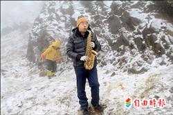 合歡山馬年首場瑞雪超有FU,來自台中的郭姓民眾在雪地中吹奏薩克斯風,為去年車禍受傷無法同行的妻子祈福。