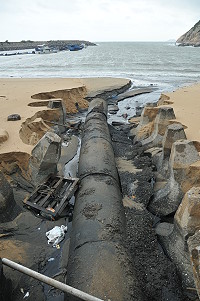 　塘岐馬鼻灣大排出海口因大雨沖刷一大凹洞，沉積多年的污染黑沙現形。（圖／文：陳鵬雄）