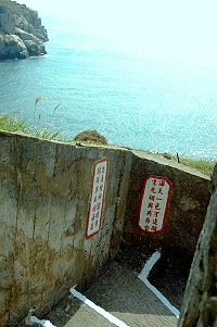 　東引「一線天」階梯兩側的舊牆上象徵戰地精神的標語，現在已遭水泥掩蓋，民代建議重現原貌，保存戰地文化景觀。（圖／文：陳其敏）