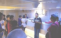 「臺馬之星」28日航前故障,新華航業公司總經理劉三光(圖中、比手勢者)登船向旅客說明狀況及造成行程受阻表示致歉。(圖:沈駿璿提供)