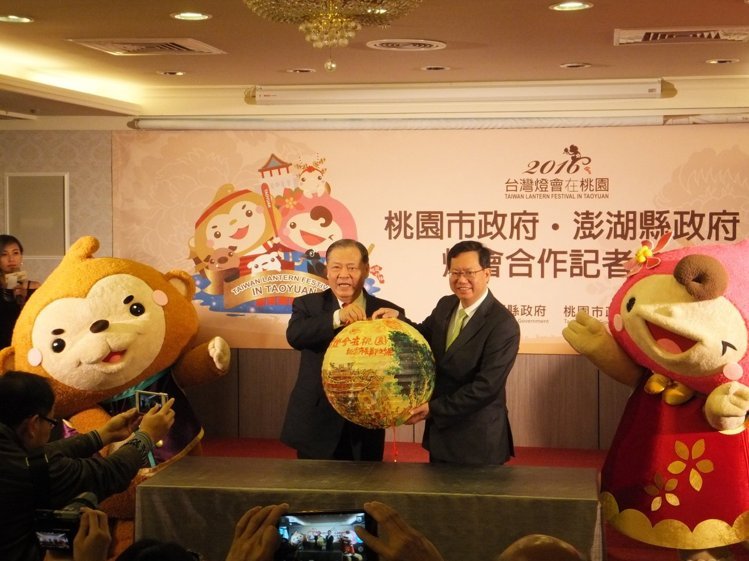 2016「台灣燈會在桃園」設有澎湖燈區,由桃園市長鄭文燦(右)、澎湖縣長陳光復共同簽署合作協定及互贈禮物,兩旁為燈會吉祥物ㄚ桃、園哥。 江衍勛 / 攝影