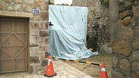 大浦聚落建物後方擋牆倒塌,已由廠商暫時處理,年後將再行修繕。(圖:工務局提供)