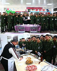 (上圖)指揮官莫中將聘任何海平老師為馬防部廚藝講師。(下圖)何海平老師現場示範「豆乾炒肉絲」料理。(圖/文:陳玉笈)
