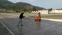 　塘岐運動場展開PU跑道第一道防水層鋪設作業。（圖／文：陳鵬雄）