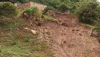 連續豪雨造成大坵聚落下方土石崩落,危及上方環島步道以及民宅基礎。(圖:張良衛)