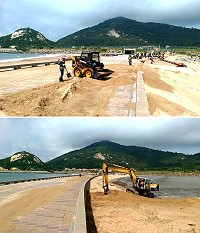 颱風過後塘后道積沙嚴重,公所與軍方動員大規模人力機具展開清沙。(圖/文:陳鵬雄)