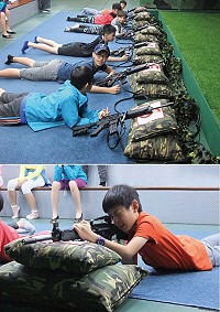 　（上圖）學子首次體驗T91步槍射擊模擬器，就射擊位置時難掩興奮之情。（下圖）學子射擊時，專注的神情。 （圖／文：黃信助）