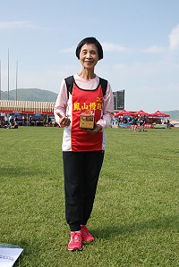 　來自高雄的64歲何秀鳳奪下10公里挑戰組女子冠軍，和獎盃開心合影。（圖／文：楊凱棻）