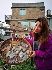 　圖為王建華老婆李翠雲手持東莒婆婆曝曬的墨魚乾。（圖：王建華提供）