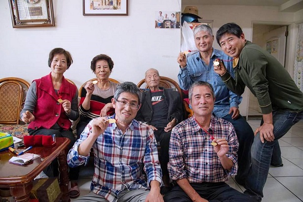 107歲津沙旅台人瑞邱依期生日前夕28日大年初一將百歲起領取6金、6戒分6子女,長女邱淑金(後排左2)、大兒子邱吉勇(前右1)。(圖/津沙客棧老闆邱吉勇提供)