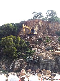 白沙聯外道進行預防性破碎岩盤剝離作業,碎石滾落坡地後再行清除。(圖/文:陳鵬雄)