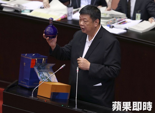 立院審查年金改革法案沉悶,馬祖選區立委陳雪生26日中午發言時帶著1瓶馬祖老酒(註/按圖:大藍寶裝15年陳高)上台,趁機打廣告。(蘋果日報趙元彬攝)