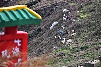 　東北季風逞威，質量輕的海漂垃圾攻佔山頭，有一部遭阻絕網攔阻，形成一道明顯髒亂景觀。（圖／文：陳其敏） 