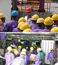 　（上圖）運輸連連長向全體作業人員下達安全規定。（下圖）搬運組在狹窄的貨艙中有條不紊地進行搬運工作。（圖／文：江耿逸）