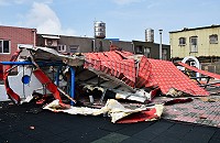　東引幼兒園大樓遭強風吹掉的附加鐵皮屋頂，鐵片、鐵條扭曲變形，工人進行切割拆解後，再清運。（圖／文：陳其敏） 