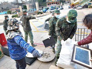 官兵協助當地居民環境清潔,恢復社區乾淨容貌。(圖/文:郭宣綸)
