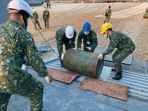 官兵協力將油桶推行上船。(圖:林政宇)