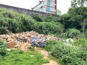 梅石新建演藝廳海邊邊坡土石滑落,往公車處、特約茶室路段山凹內存放石材,非人為傾倒工程廢土。(圖:連江縣環資局提供)
