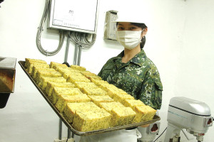 江上兵端著剛出爐的美味大蒜奶油麵包,歡迎大家來品嘗!(圖:陳柏村)