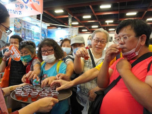 台北國際夏季旅展馬祖展館推出馬祖、東湧高粱特調品嘗體驗會,吸引遊客圍觀分享暨宣傳莒光定向越野暨夜跑活動。(圖:白日夢創意開發公司馬祖分公司)