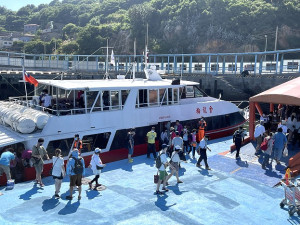 　旅遊補助加碼遊客增加，22日上午白沙碼頭同時有10部遊覽車待命接客。（圖／文：陳鵬雄）