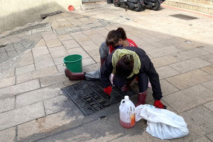 東引南澳街道,部分水溝格柵蓋板沾黏著厚厚一層油垢,鄉公所派遣清潔人員進行清洗刮除。(圖:民眾提供)
